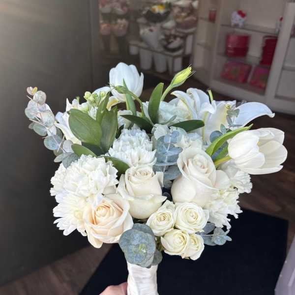 White bouquet with roses, lilies, carnations, and eucalyptus
