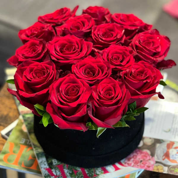 Red roses arranged in a black round box