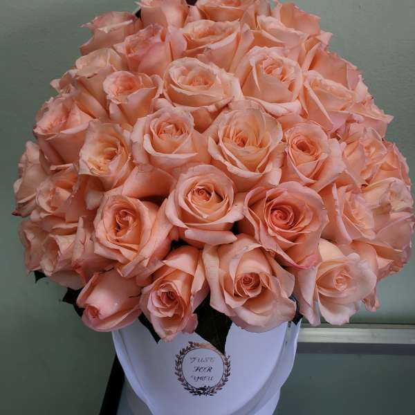 Bouquet of peach roses in a white hatbox