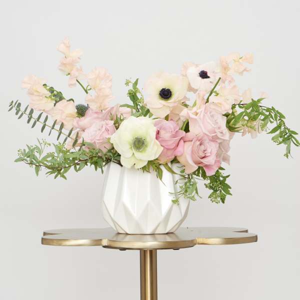 Pink and white floral arrangement in a white vase