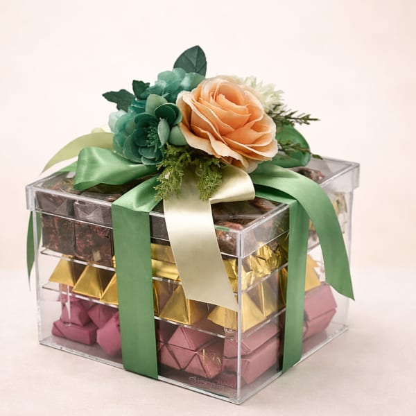 Gift box with flowers on top and wrapped chocolates inside