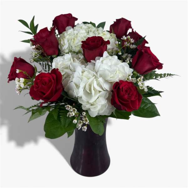 Red roses and white hydrangeas in a dark vase