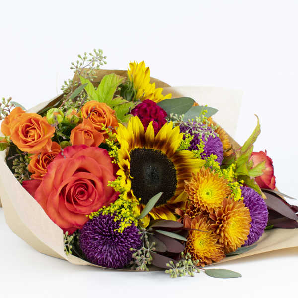 Bouquet of orange roses, sunflowers, and purple chrysanthemums wrapped in paper