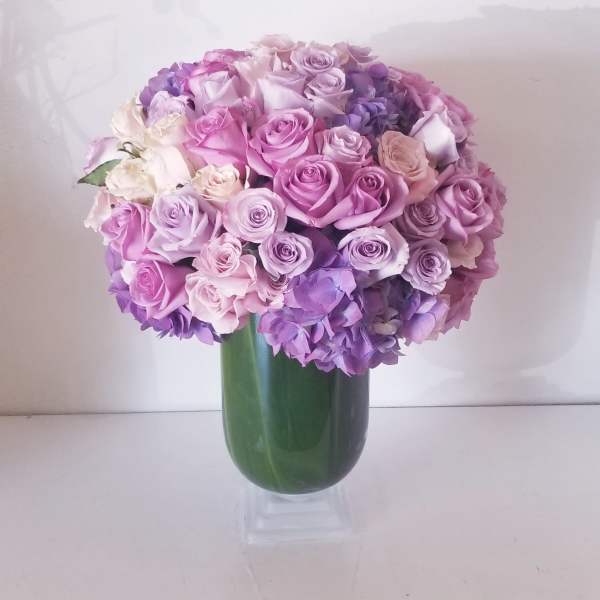 Bouquet of pink and lavender roses in a green vase