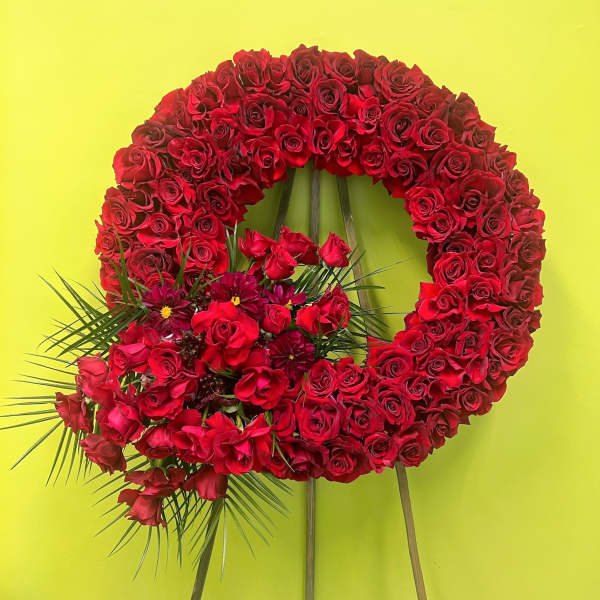 Large red rose wreath with a floral cluster at the lower left