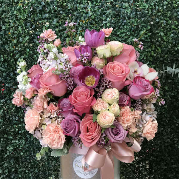 Pink and purple rose bouquet in a silver box with a satin ribbon