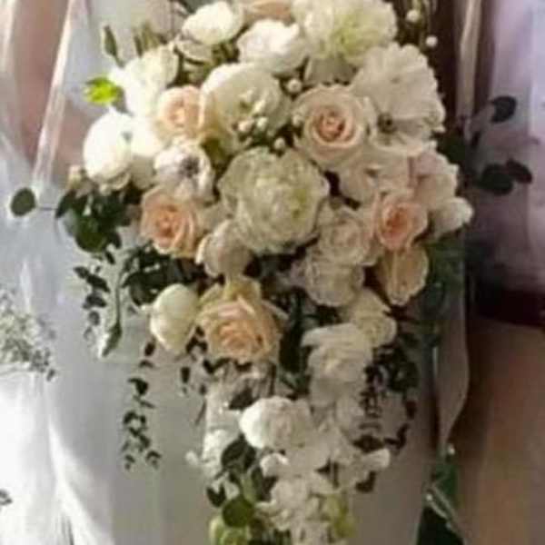 Bride holding a cascading bouquet of white and blush flowers