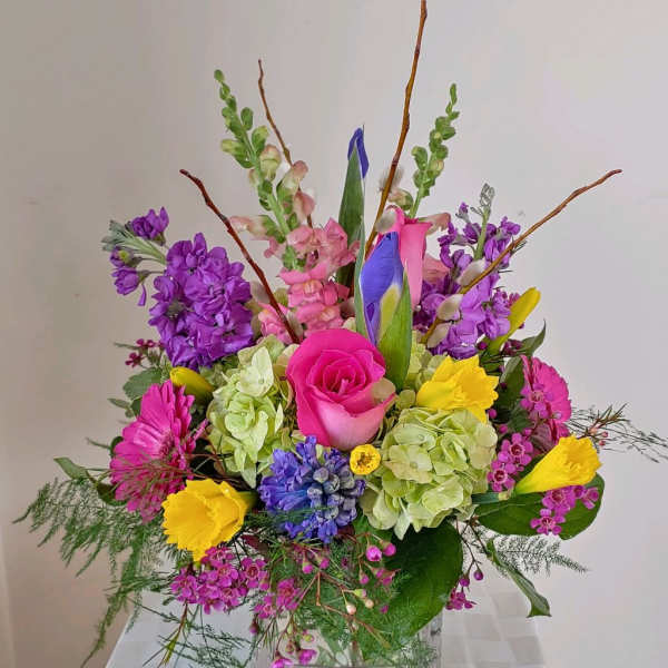 Colorful mixed flower arrangement in a clear glass vase