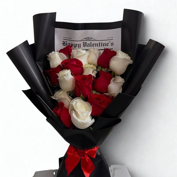 Bouquet of red and white roses wrapped in black paper with a red ribbon