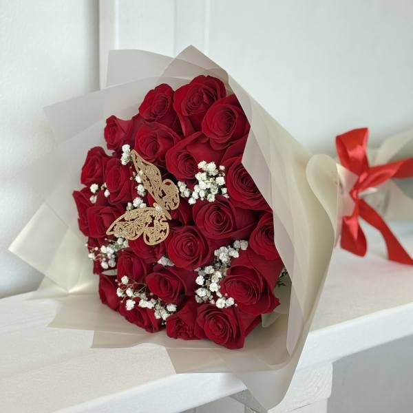 Bouquet of red roses with baby's breath in cream wrapping