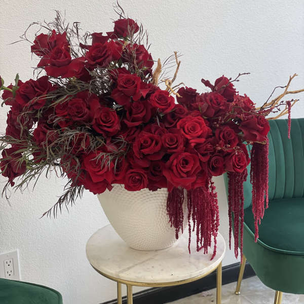 Large arrangement of red roses in a white vase