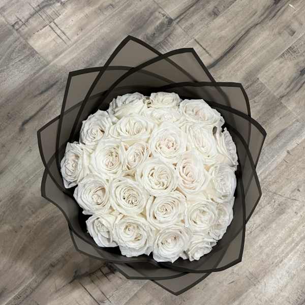 Round bouquet of white roses wrapped in black paper