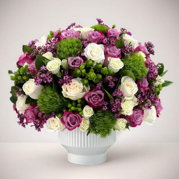 Bouquet of pink, white, and purple roses in a white vase