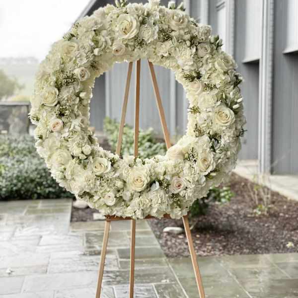 White floral wreath on a wooden easel
