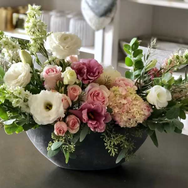 Mixed floral arrangement in a dark bowl vase with pink, white, and purple blooms