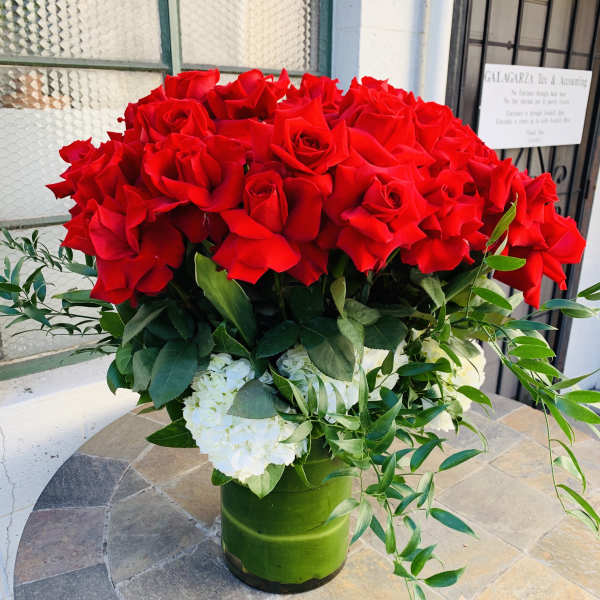 Large bouquet of red roses with white hydrangeas in a green vase