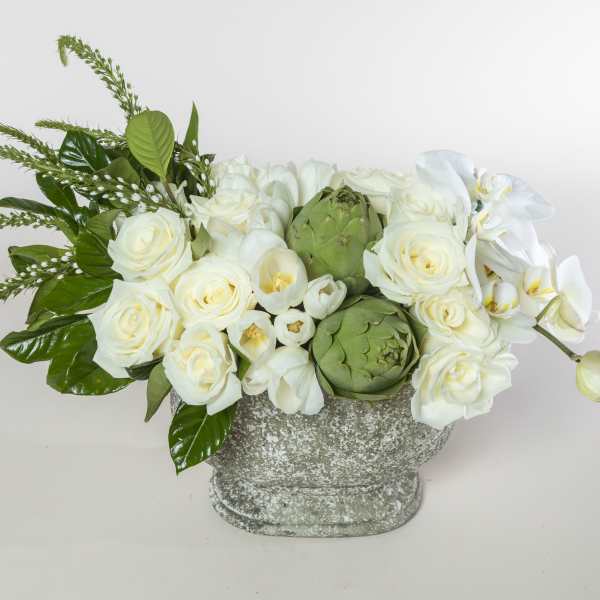 White roses and orchids in a textured gray vase