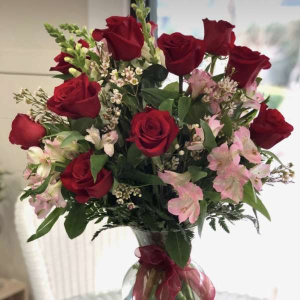 Bouquet of red roses and pink alstroemeria in a clear glass vase