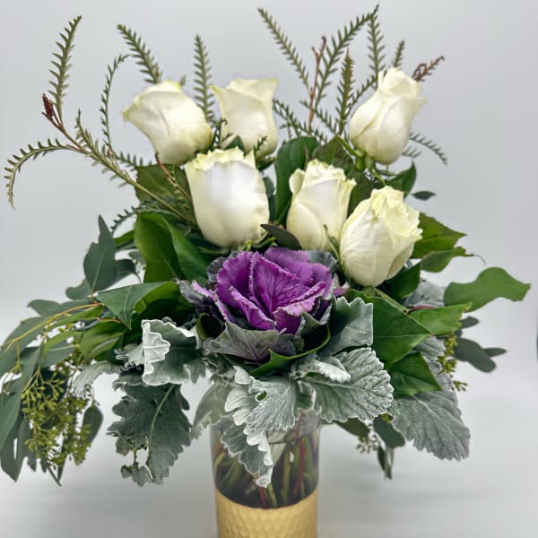 White roses and purple ornamental cabbage in a gold vase