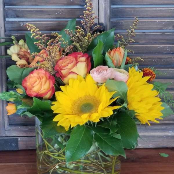 Bouquet of sunflowers and roses in a glass vase