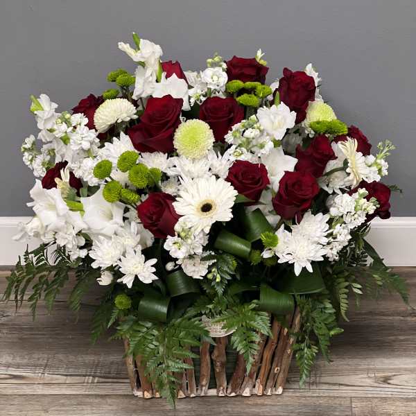 Red roses and white flowers in a rustic basket arrangement
