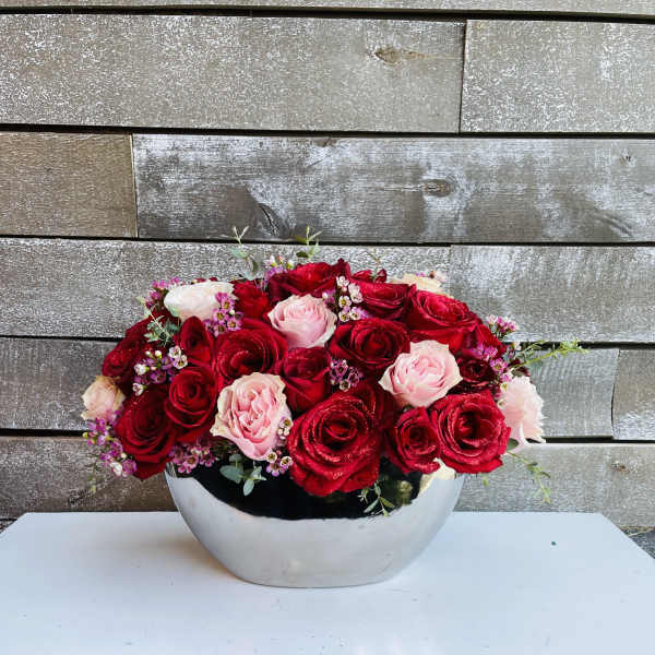 Red and pink roses arranged in a silver bowl