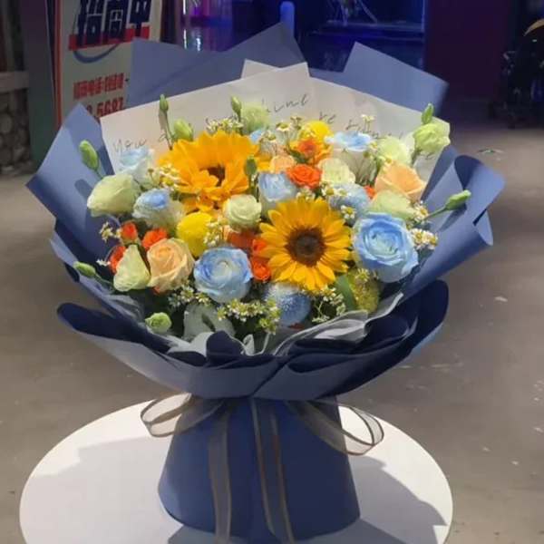 Bouquet of sunflowers and pastel roses wrapped in blue paper