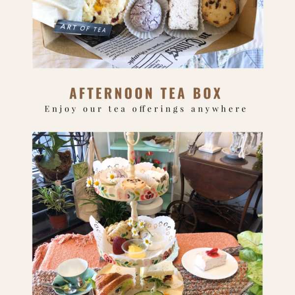 Afternoon tea box and tiered stand with assorted sandwiches, pastries, fruit, and small flower garnishes.