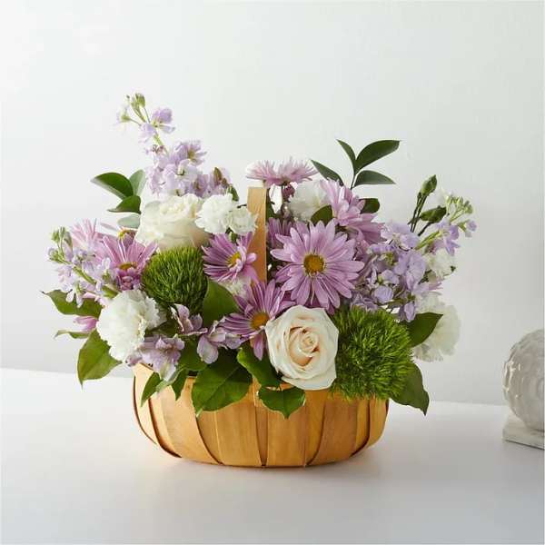 Lavender and white flower arrangement in a wooden basket