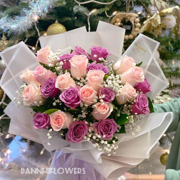 Bouquet of pink and purple roses wrapped in white paper