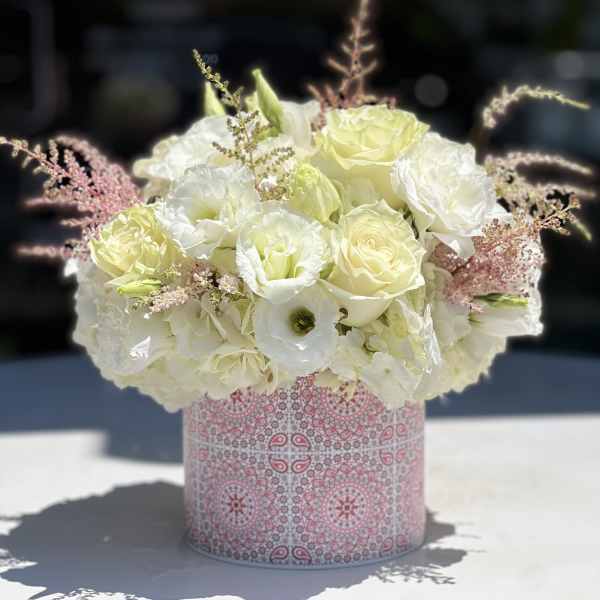 White and pale yellow bouquet in a pink patterned box