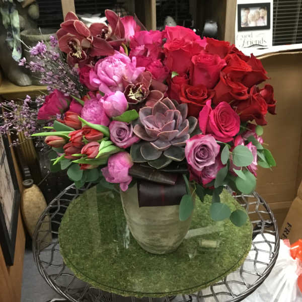 Bouquet of red and pink roses with orchids in a vase