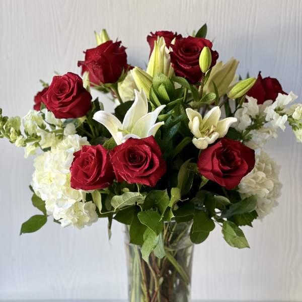 Red roses and white lilies arranged in a clear glass vase