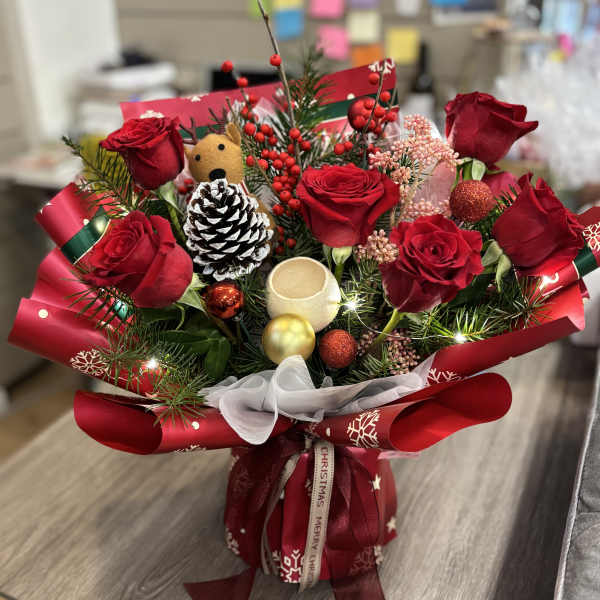 Red rose bouquet with Christmas ornaments and ribbon wrap