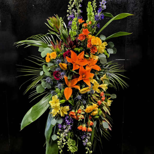 Tall tropical floral spray with orange lilies and mixed blooms