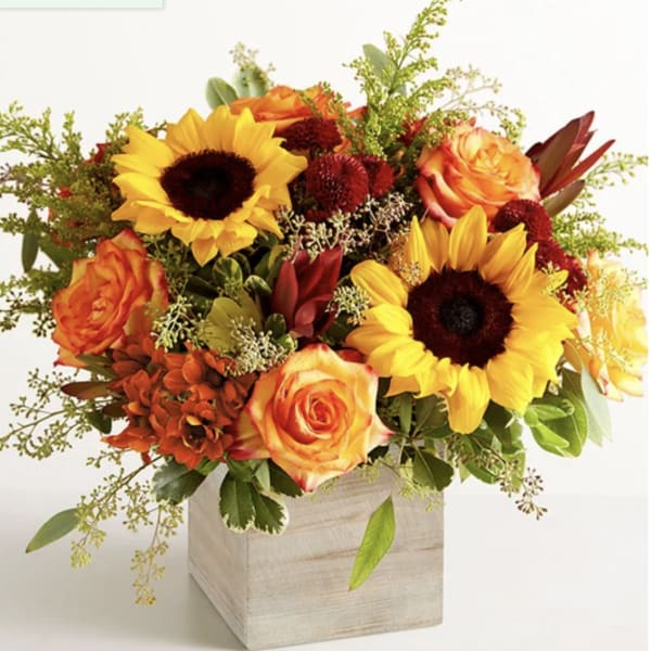 Bouquet of sunflowers and orange roses in a wooden box