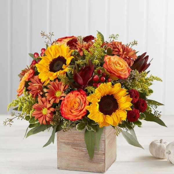 Autumn bouquet with sunflowers, roses, and mums in a wooden box