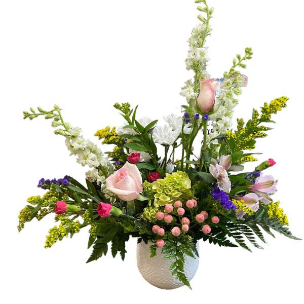 Mixed floral arrangement in a white textured vase with pink roses and white blooms