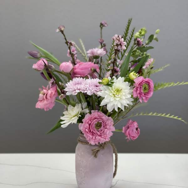 Pink and white mixed bouquet in a lavender vase