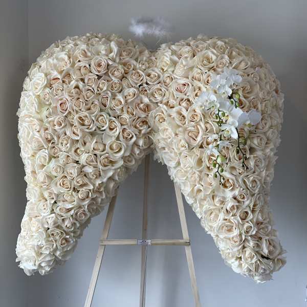 Large heart-shaped floral spray of cream roses on an easel