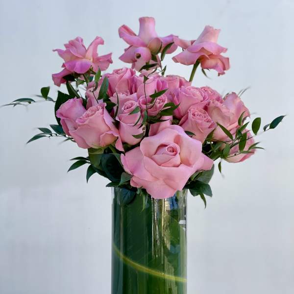 Pink roses arranged in a clear glass vase
