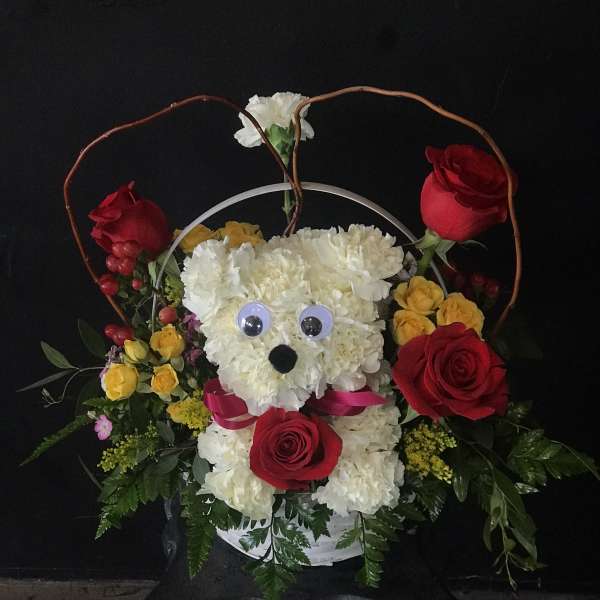 Floral basket with a teddy bear face made of white flowers and red roses
