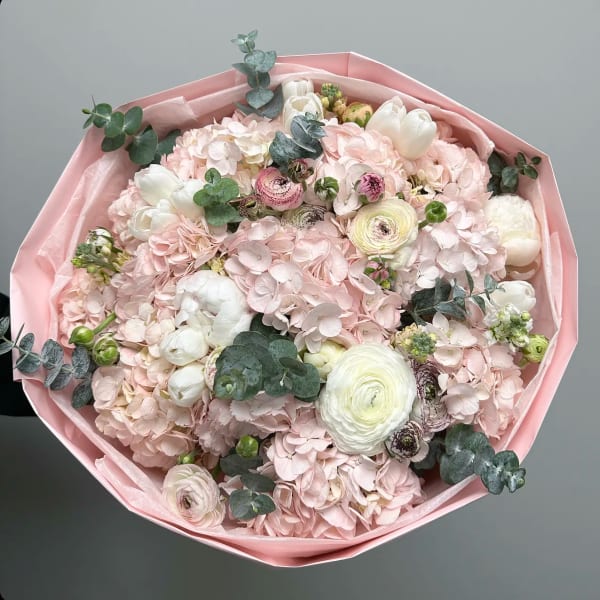 Bouquet of pale pink flowers with white blooms and eucalyptus in pink wrap