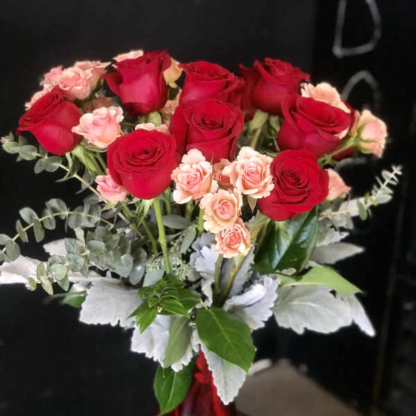 Red and pink roses arranged in a red vase