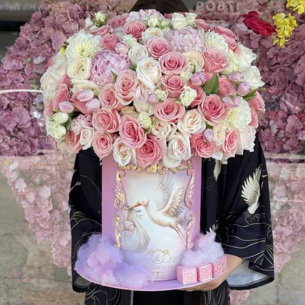 Pink and white rose arrangement in a decorative box with a bird illustration