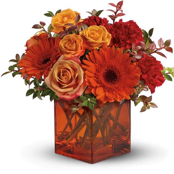 Orange and red flowers arranged in a square glass vase