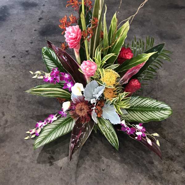 Tropical floral arrangement with orange heliconia and pink orchids