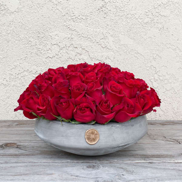 Low arrangement of red roses in a gray bowl vase