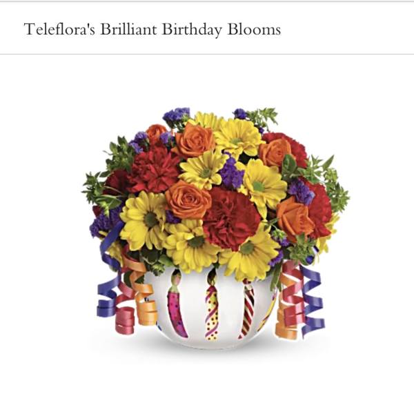 Colorful bouquet in a white vase with curled ribbon decorations