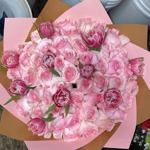 Pink rose and tulip bouquet wrapped in pink and brown paper